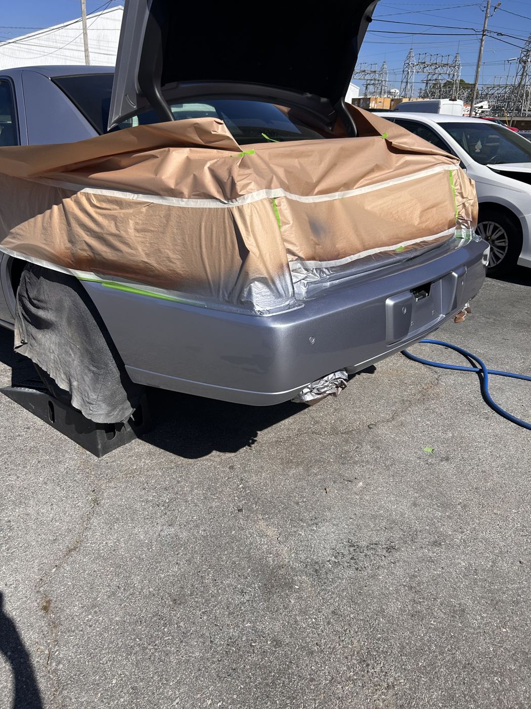 Cadillac rear bumper masked in a parking lot