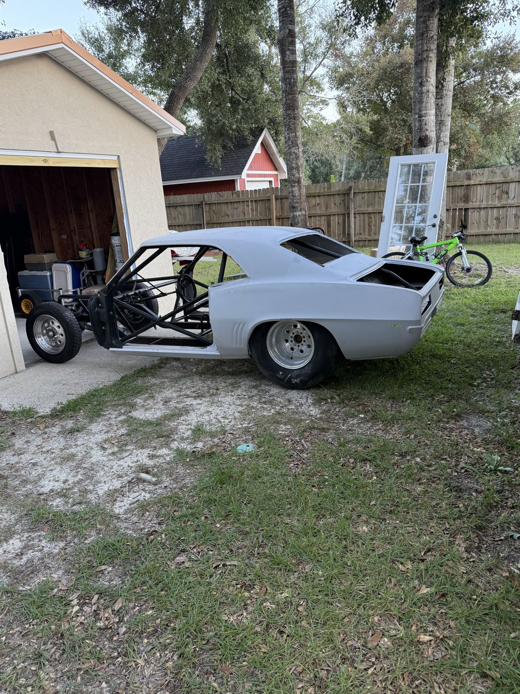 Caged Camaro race car body in a yard