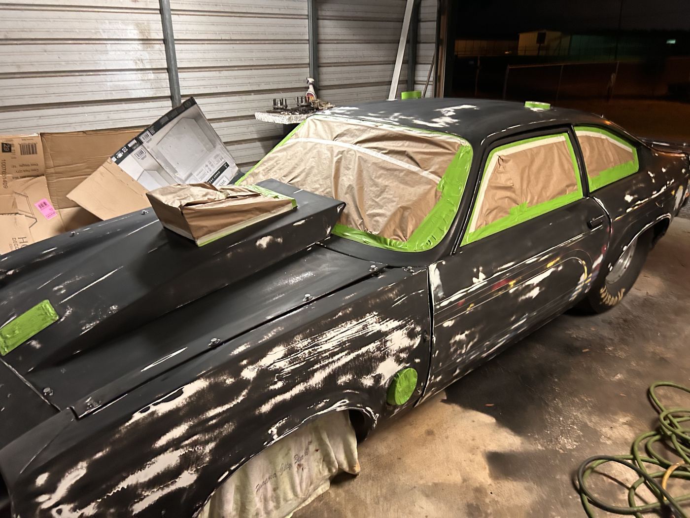 Drag race car sanded and masked in a carport