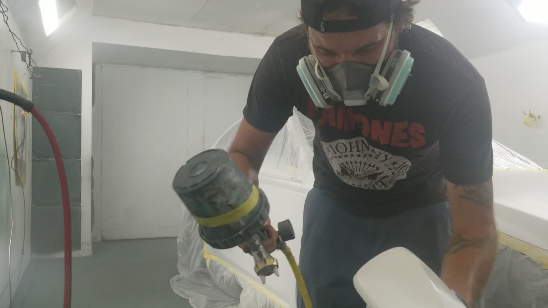 Kyle Pearson in a respirator spraying paint